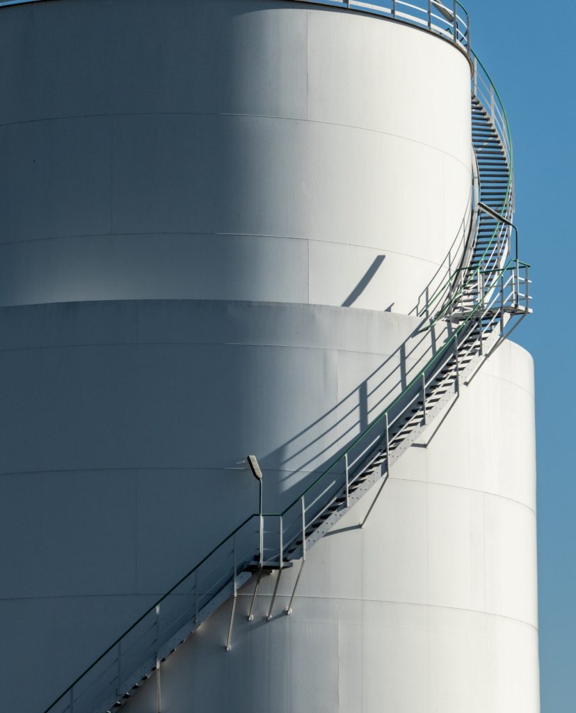 An industrial storage tank with an external spiral staircase