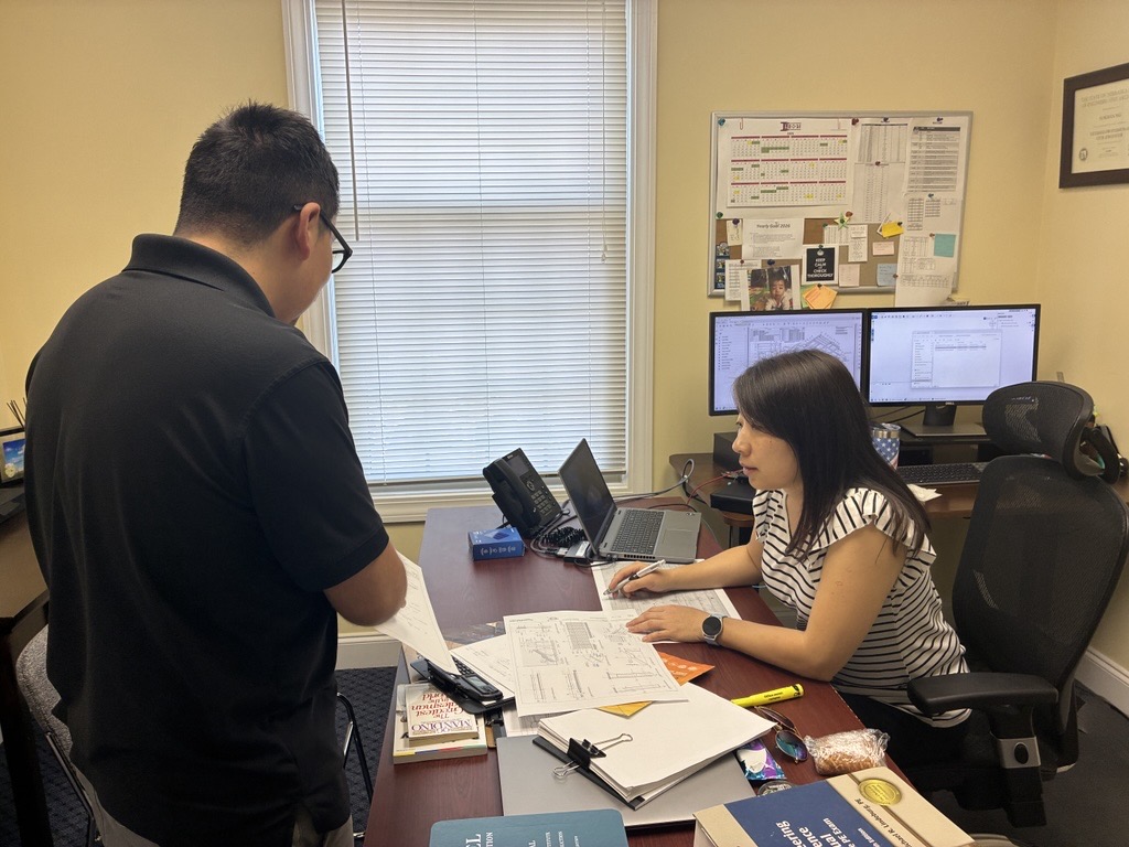Two LECGI engineers reviewing structural drawings together at a workstation